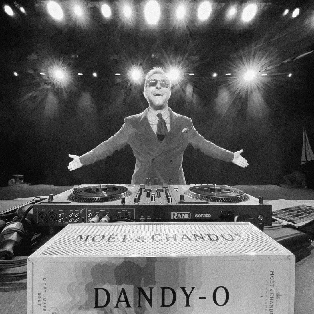 DJ Dandy O. behind the turntables, celebrating with Moet & Chandon champagne right in front of him.
