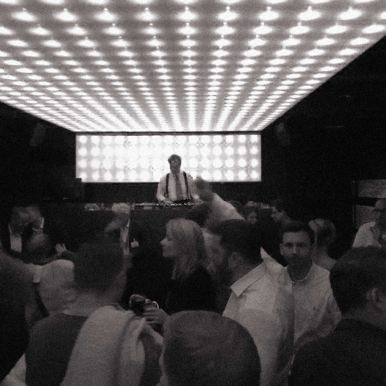 DJ Dandy O. playing in front of dancing people in a club.